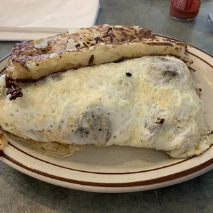 Egg white omelette with chicken, mushrooms, peppers and onions and a side of hash browns.