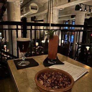 a bowl of nuts and a drink