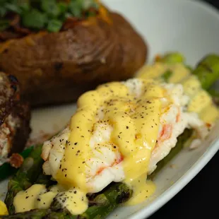 a plate of food with potatoes, asparagus, and lobster