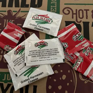 Grated Parmesan cheese and chili flake packets.