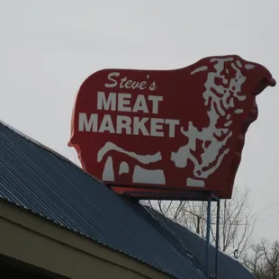 a red cow on top of a building
