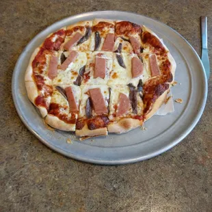 a pizza with ham and mushrooms