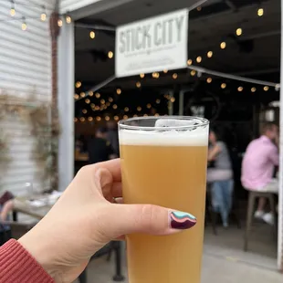 a person holding a glass of beer