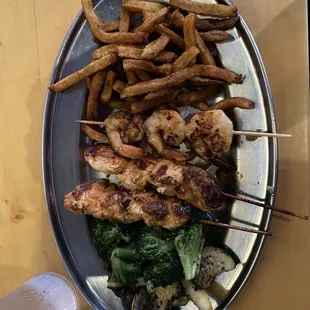 Chicken and shrimp kabobs, veggies and fries.