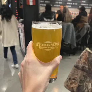 a person holding a pint of beer
