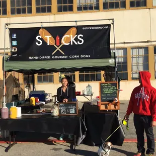 two people and a dog at an outdoor market