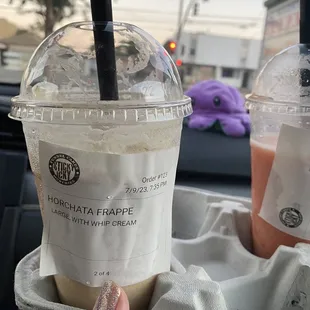 a person holding a cup of iced coffee