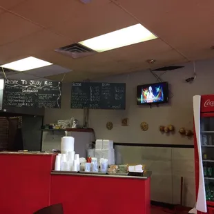 a restaurant counter with a television above it