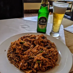 a beer and a plate of noodles