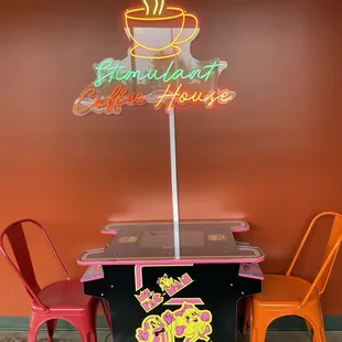 a cup of coffee and a neon sign