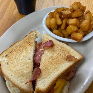 Fried Bacon &amp; Egg sandwich and Home Fries with coffee.