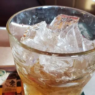 a glass of beer with ice in it