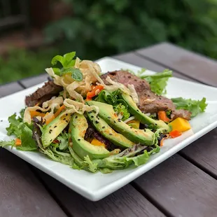 a plate of salad on a wooden table