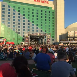 a large crowd of people sitting on the grass
