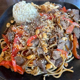 Noodles, beef, red bell peppers, peanuts and brown rice.