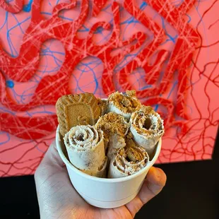 a hand holding a bowl of food