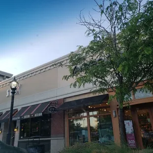 the outside of a restaurant with a street sign