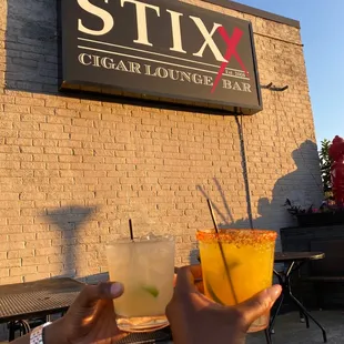 a person holding a drink in front of a restaurant