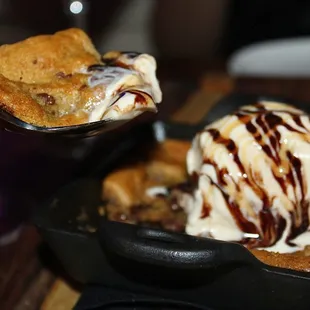 Cookie heaven! The gooey, chewy chocolate chip cookie was served warm in a skillet &amp; topped with cold, vanilla bean ice cream.