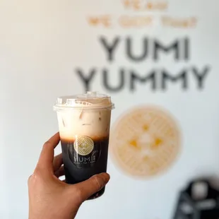 a hand holding a cup of iced coffee