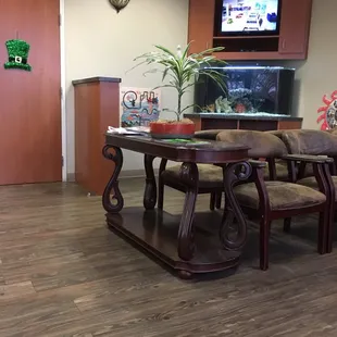 Clean and beautiful waiting room. Comfy chairs with armrests, tv on, fish tank calm and serene.