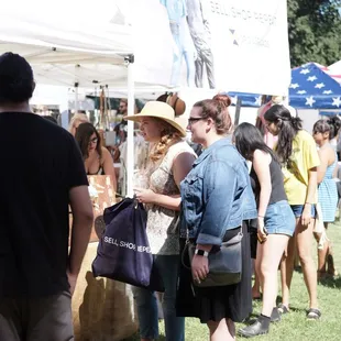 a crowd of people at an outdoor market