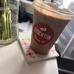 a cup of coffee and a vase of flowers