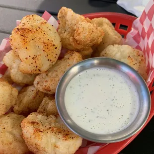 a basket of fried cauliflower with a side of ranch dip