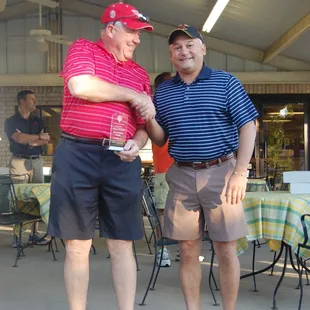 two men shaking hands at outdoor event
