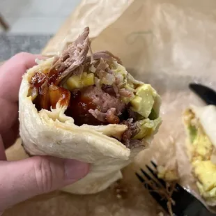 a hand holding a burrito