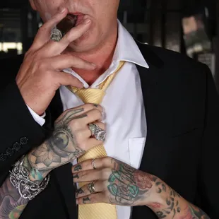 a tattooed man smoking a cigarette