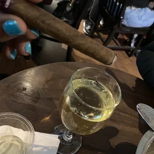 a glass of white wine and a cigar