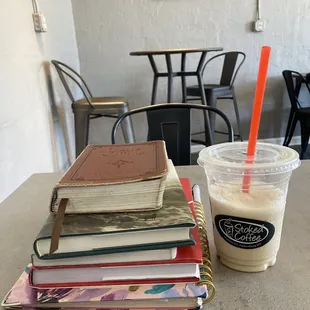 a stack of books and a drink