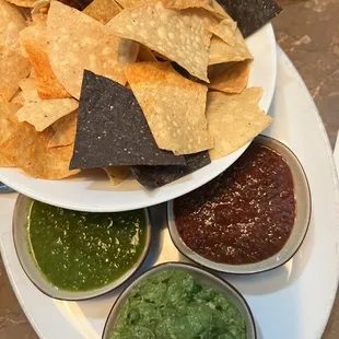 Guacamole, chips, and two salsas.