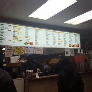 two people standing in front of a menu