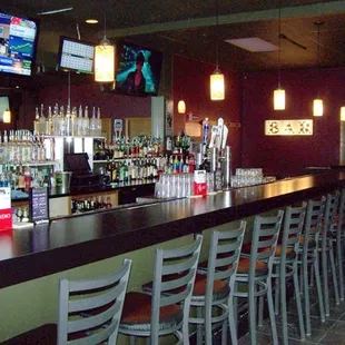 a bar with chairs and televisions