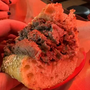 a hand holding a sandwich