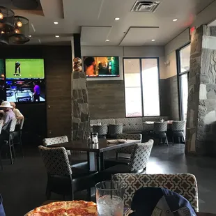 a man sitting at a table with a pizza in front of him