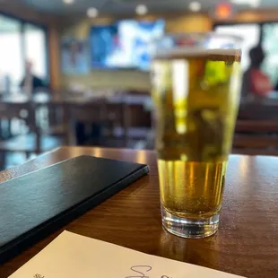 a glass of beer and menu
