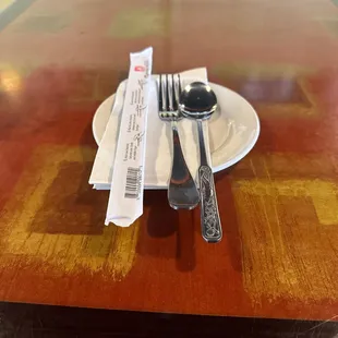 Chop sticks, fork, spoon, napkin and plate.