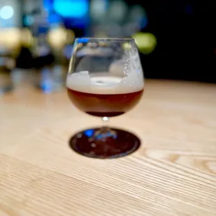 a glass of beer on a wooden table