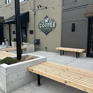 a wooden bench in front of a coffee shop