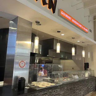 a restaurant counter with a sign above it