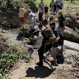 Holding onto a rope to go across a mini creek (Sep 2023)