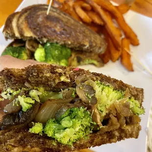 a hand holding a half eaten sandwich