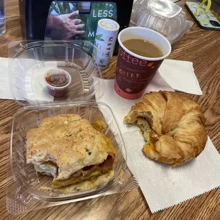 a croissant sandwich and a cup of coffee