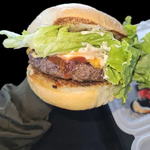 Cheeseburger with lettuce, ketchup, and mayonnaise.