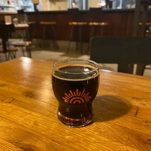 a glass of beer on a wooden table