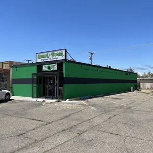 a parking lot with a green building
