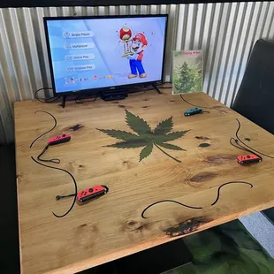 a table with a computer and a marijuana leaf on it